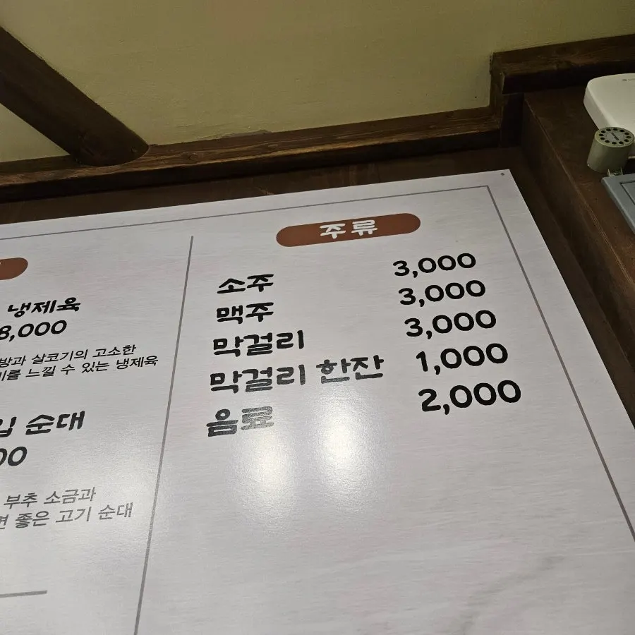 Menu board listing kettle-boiled pork gukbap and osori-muchim