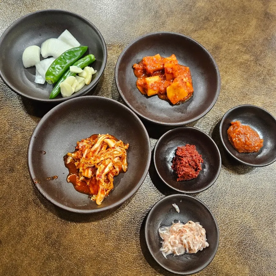 Kkakdugi and fresh kimchi served alongside the pork gukbap