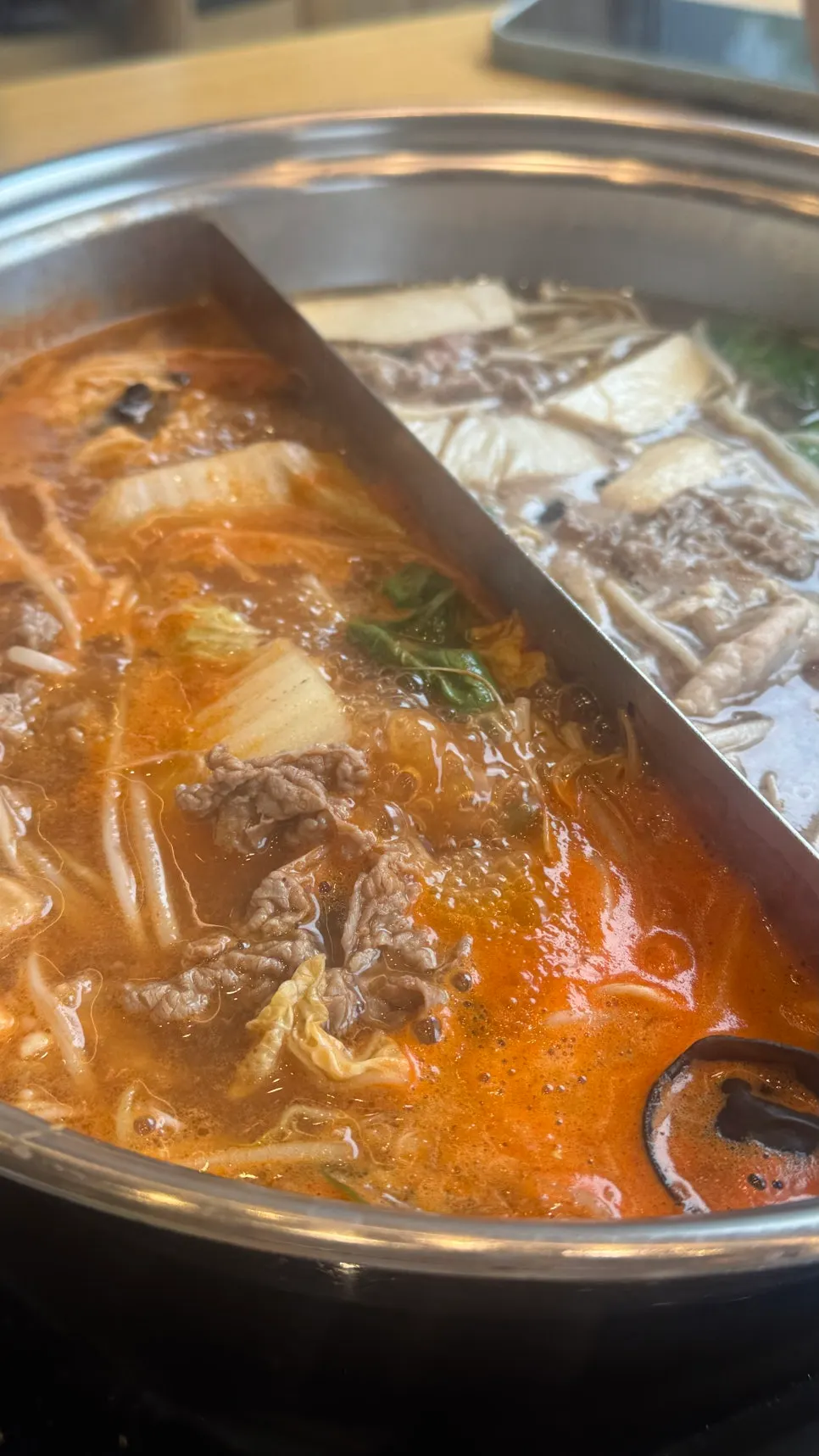 A shabu-shabu table piled high with ingredients