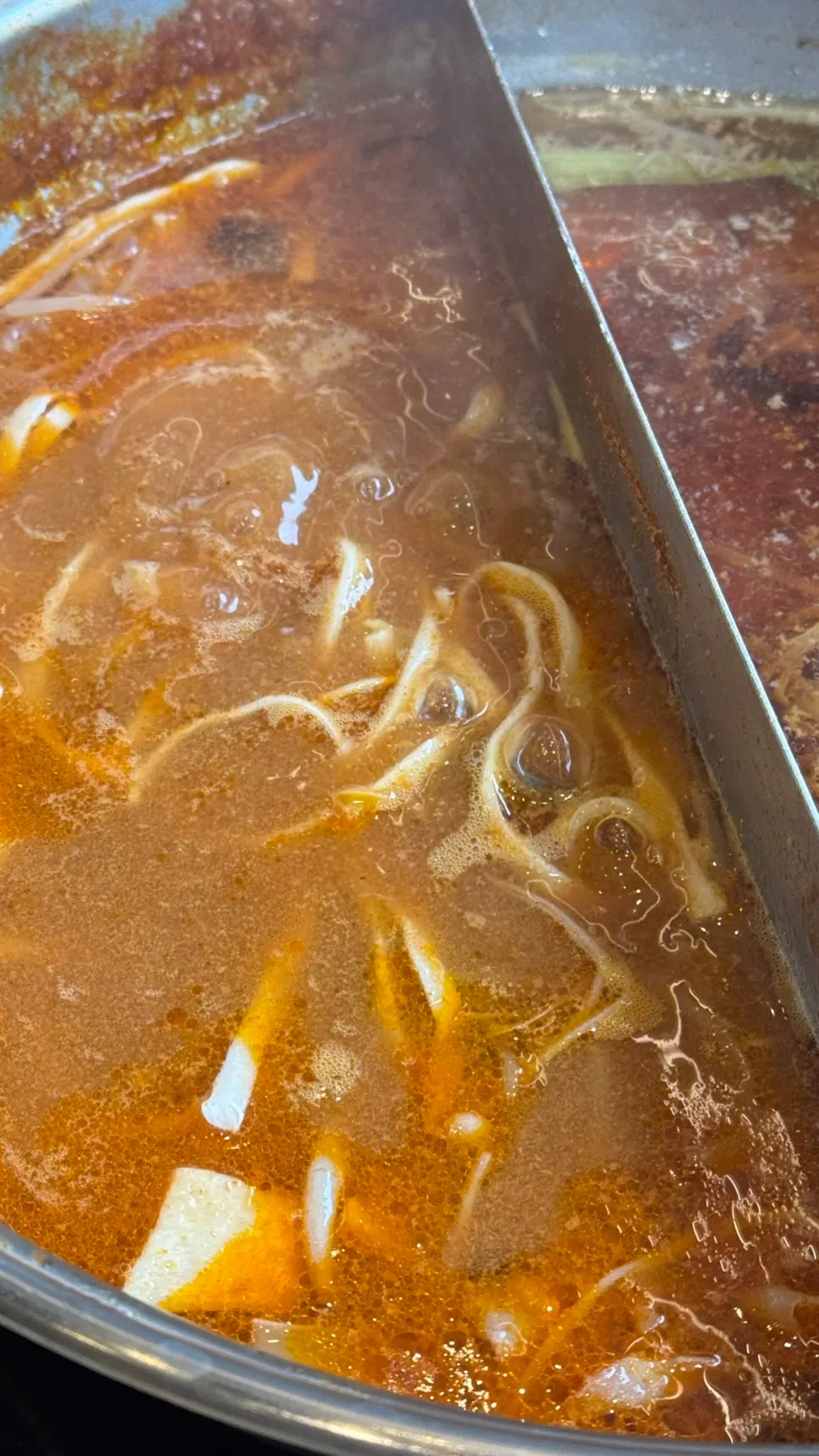 A pot split half sukiyaki, half spicy broth