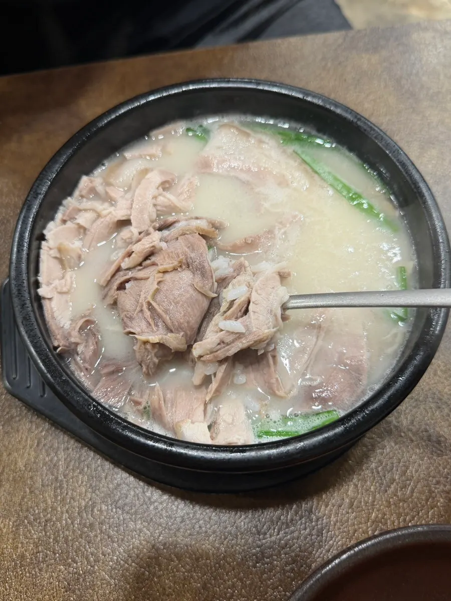 A spoonful of rice mixed into the gukbap with meat