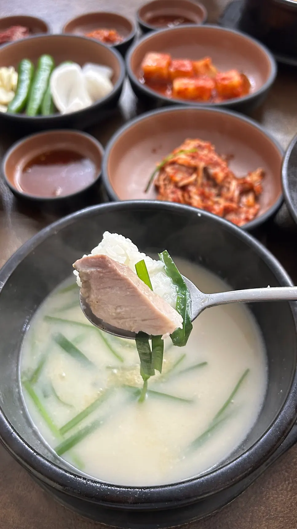 Wrapping boiled pork in lettuce as ssam