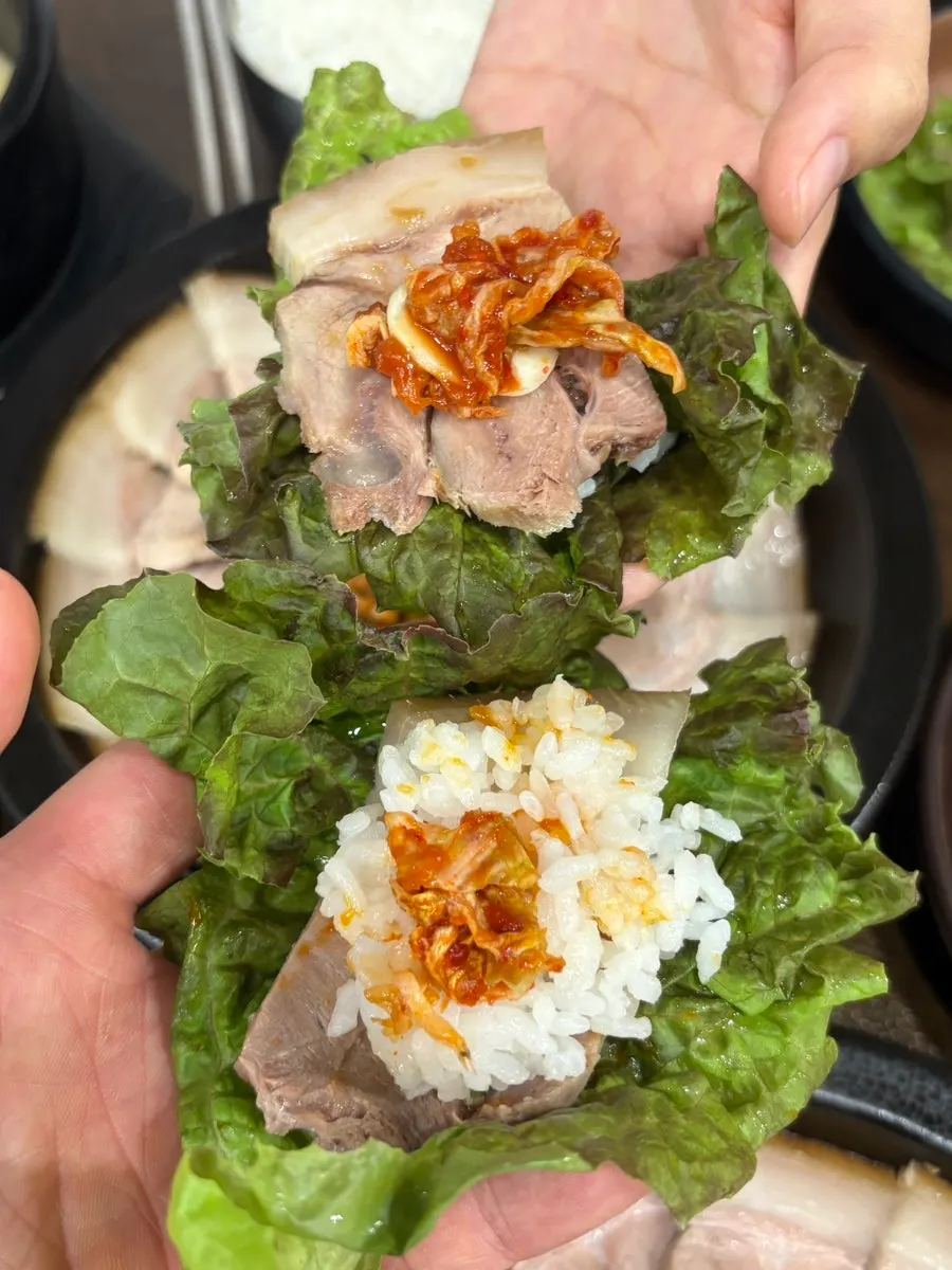 A piece of suyuk dipped in housemade soy sauce