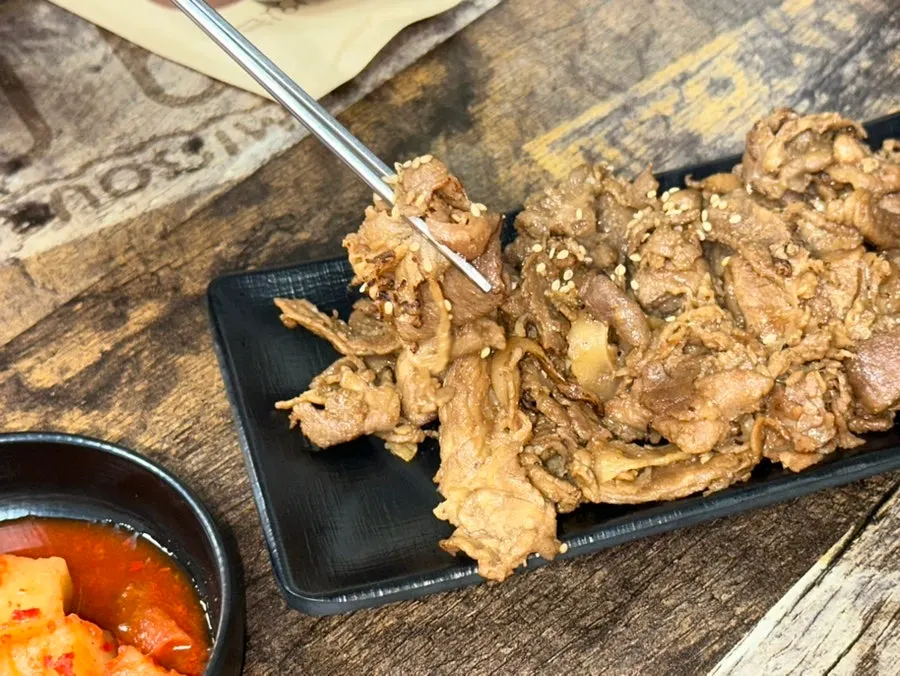 젓가락으로 집어 든 석쇠불고기 한 점