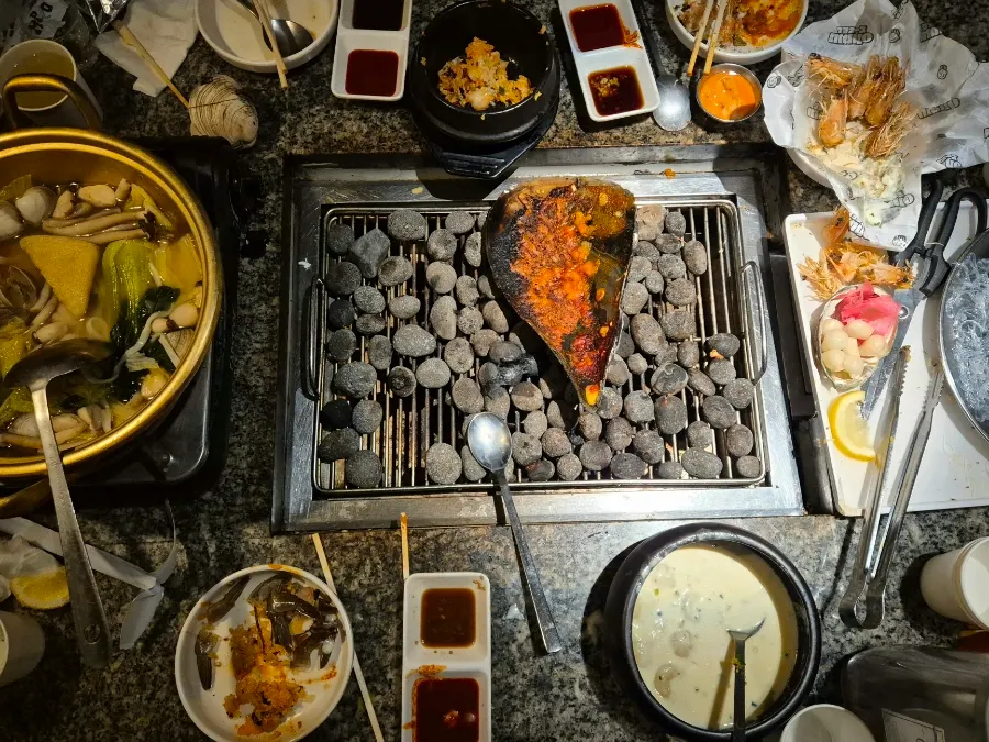 A table at Nampo spread with grilled shellfish and seafood dishes