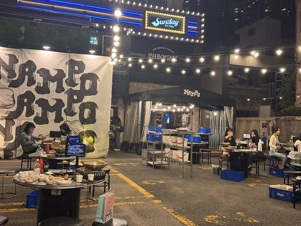 View of the outdoor street tables at Nampo, a shellfish grill pub in Gyodong, Daegu