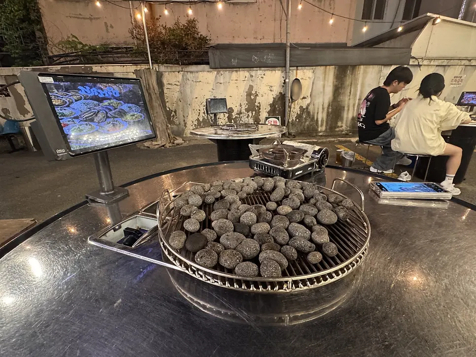 Indoor seat at Nampo with a pebble-lined grill set up