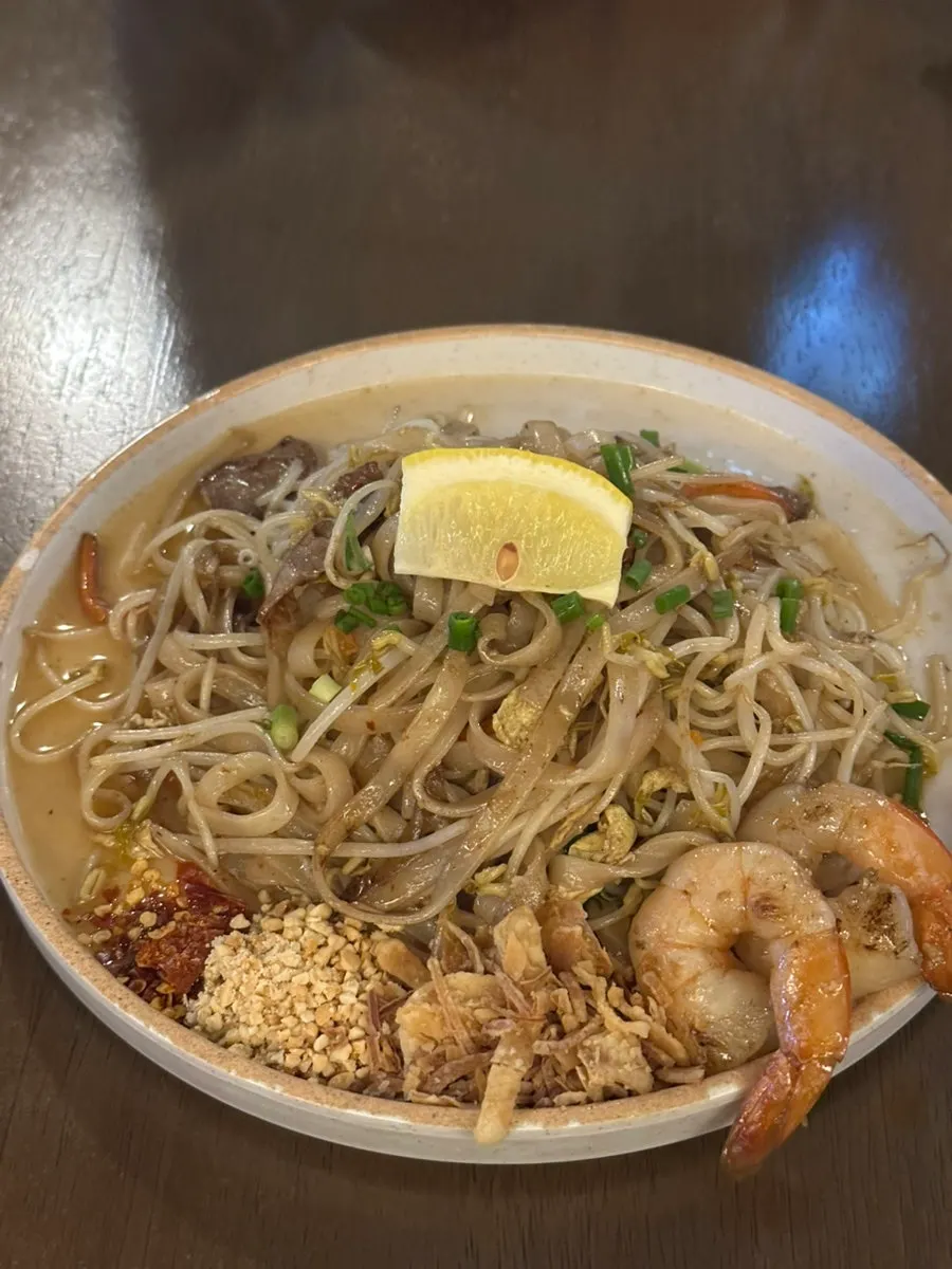 Close-up of pad thai topped with a lemon wedge