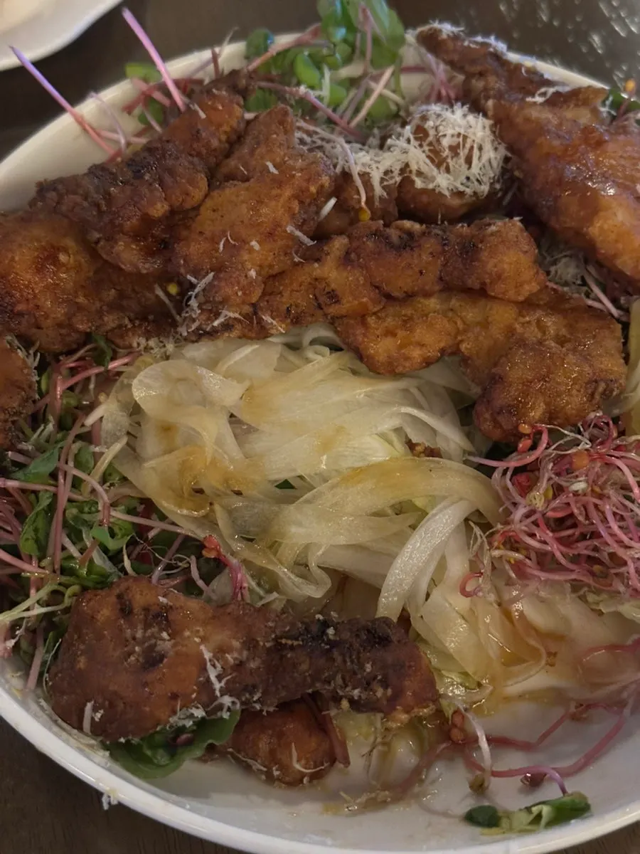 Julienned onion laid under the fried chicken