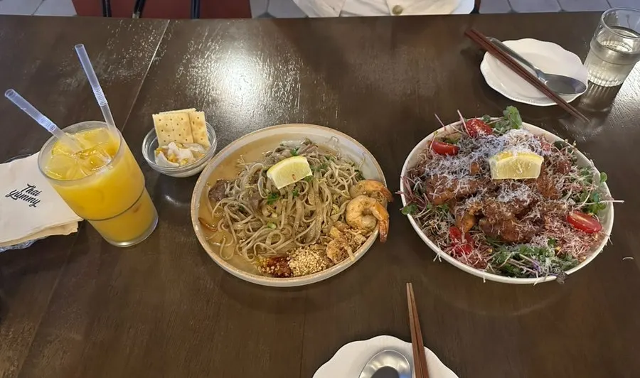 A table set with pad thai and kai phrai
