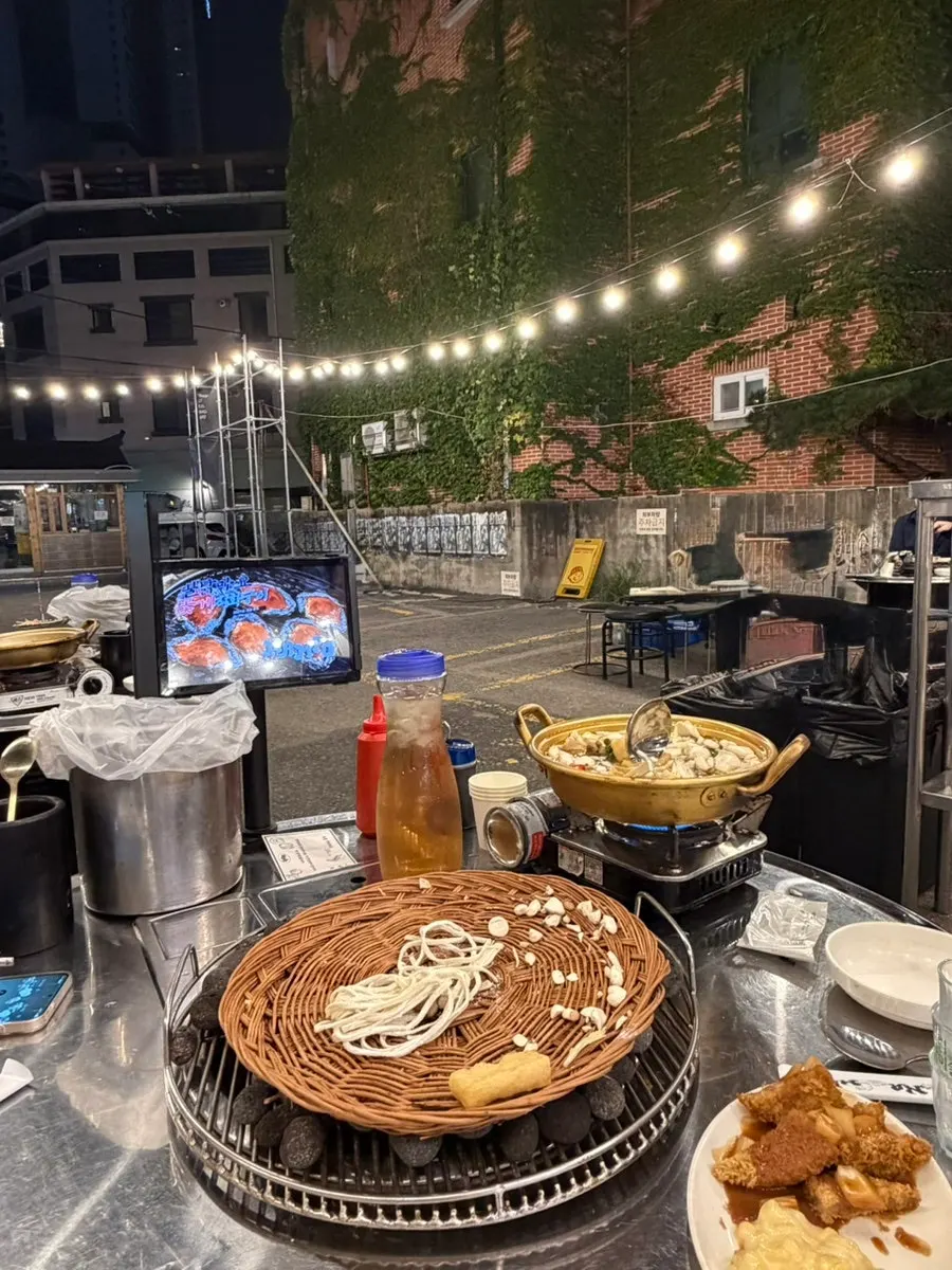 Round outdoor tables at Nampo under string lights