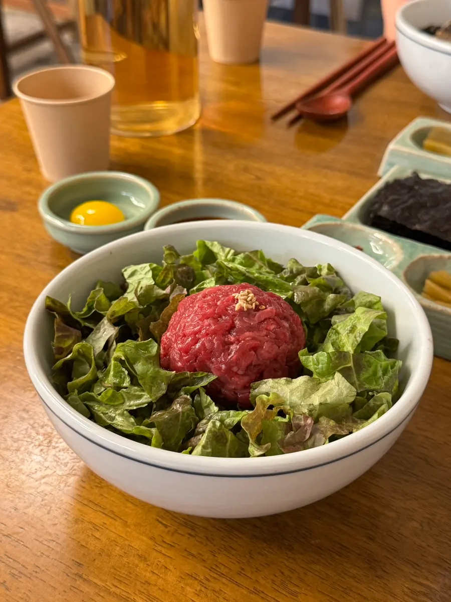Yukhoe bibimbap with sauce and egg yolk served separately
