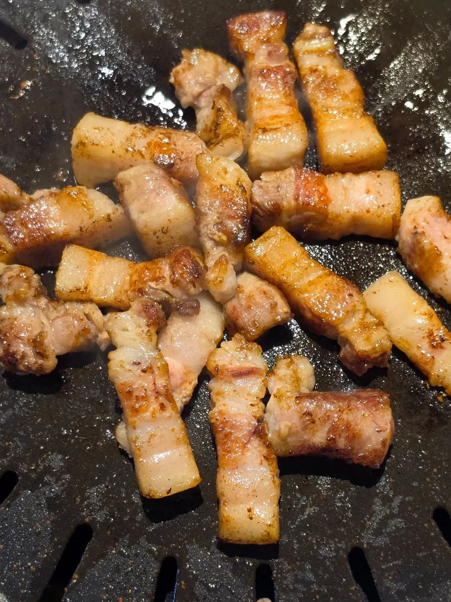 Golden-brown grilled pork belly on the grill