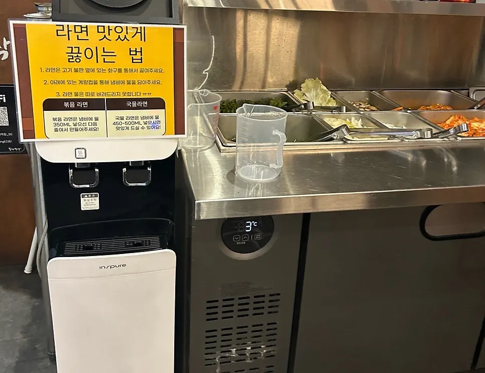 Ramyeon packets and yellow metal pots at the self-bar