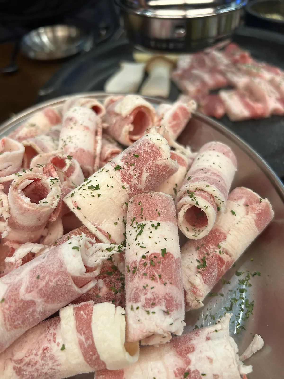 Pork belly grilling on the plate together with kimchi