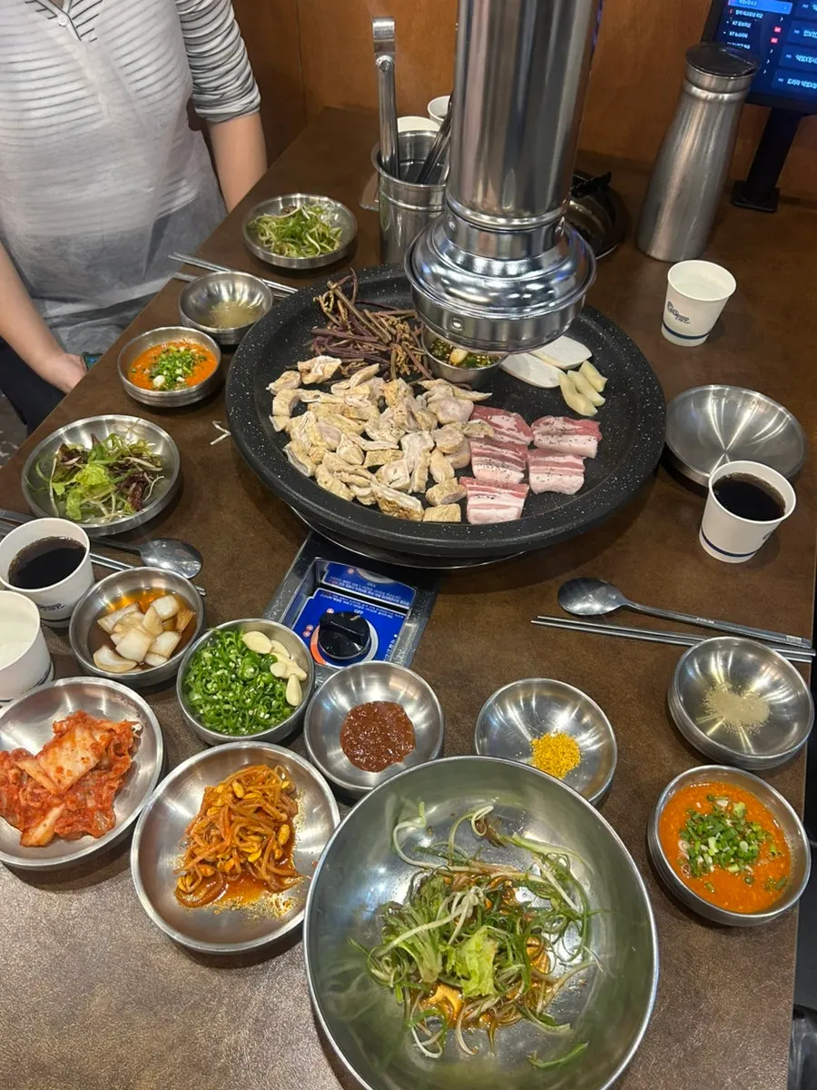 Raw makchang, raw pork belly and fern on the grill