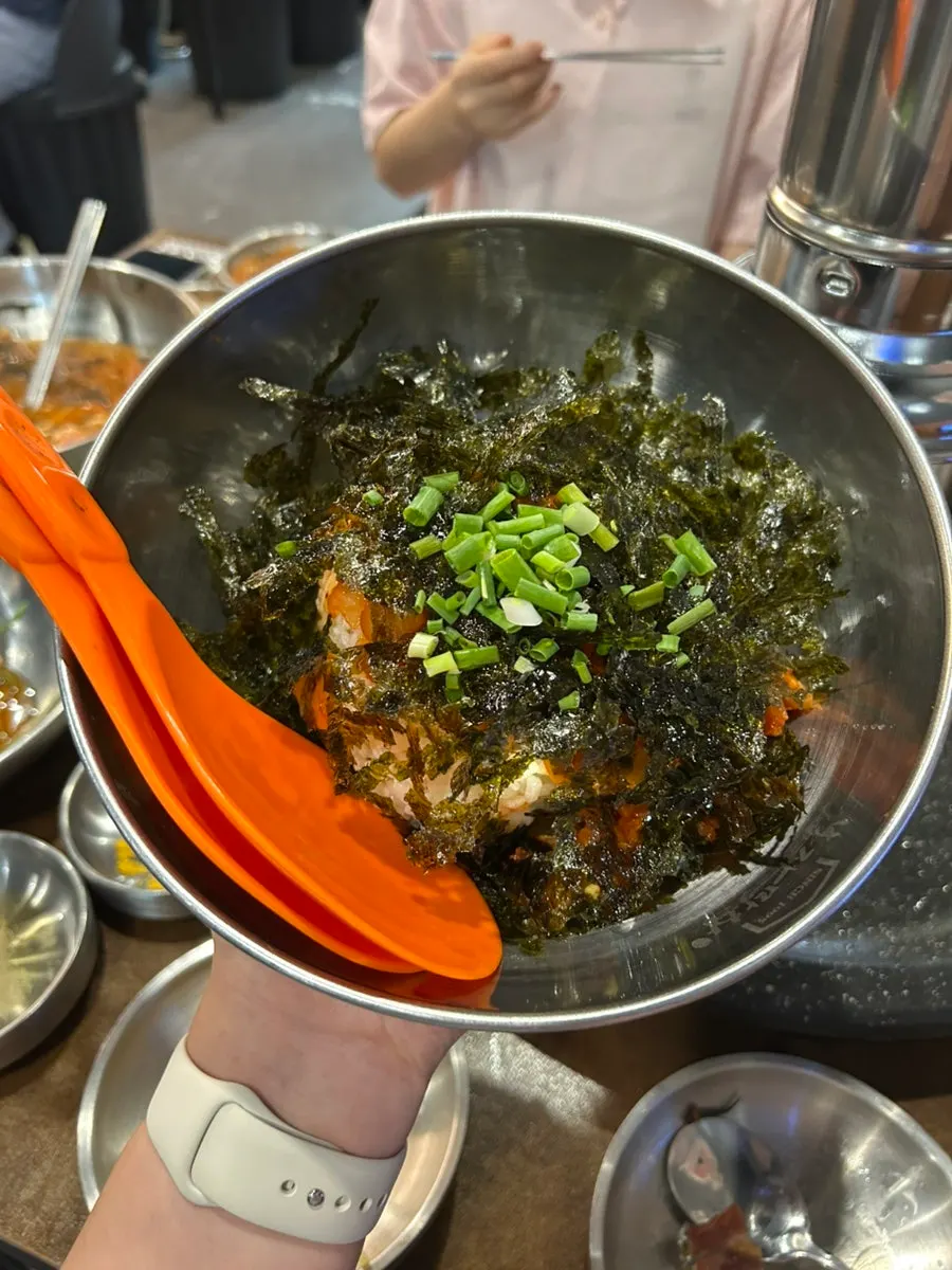 A chopstick-full of cold kimchi noodle soup noodles