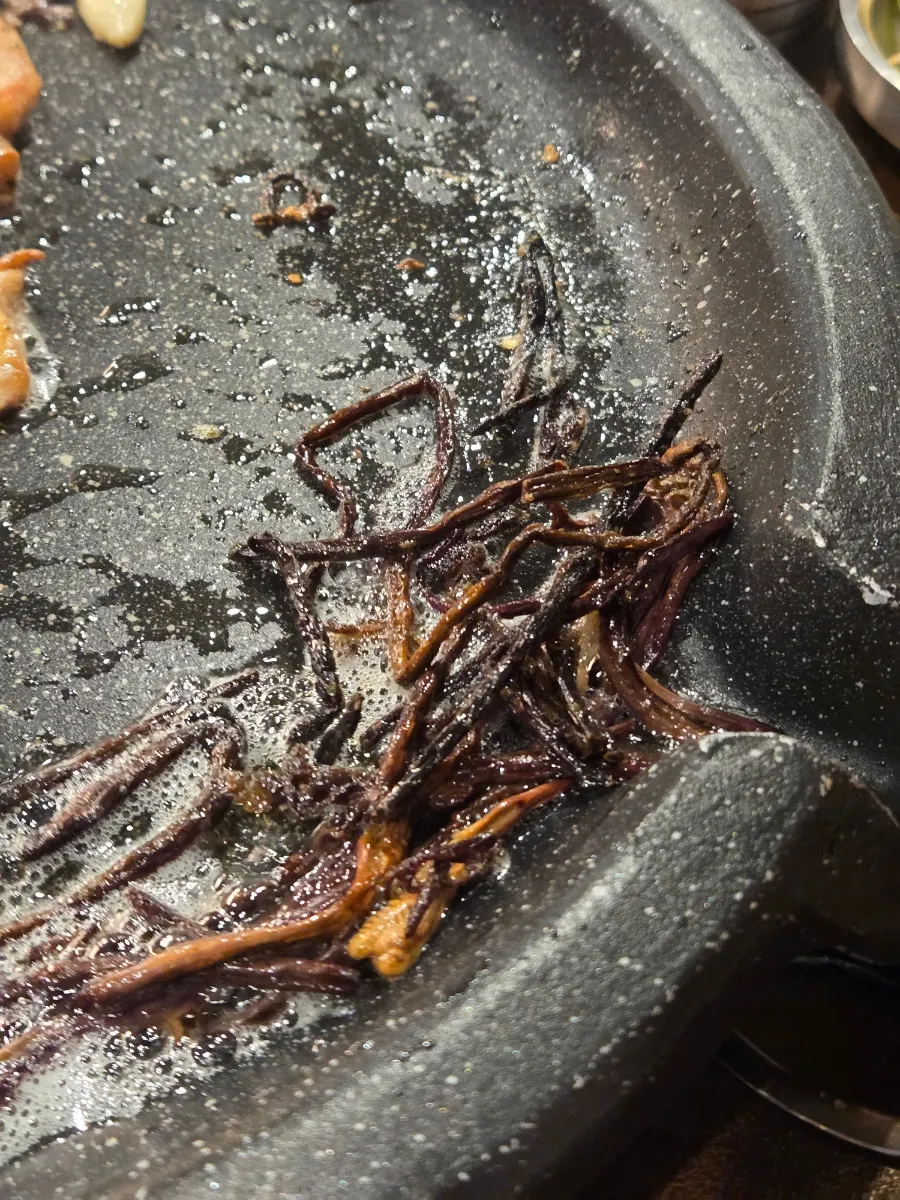 Golden-brown raw makchang cooking on the grill