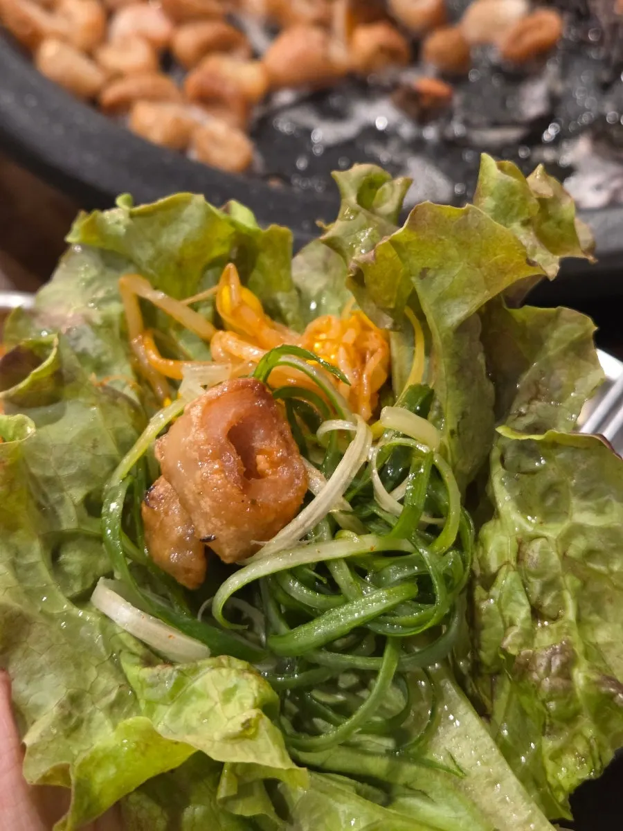 A piece of raw makchang dipped in sauce