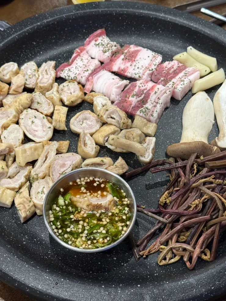 Table setting with one plate each of raw makchang and raw pork belly