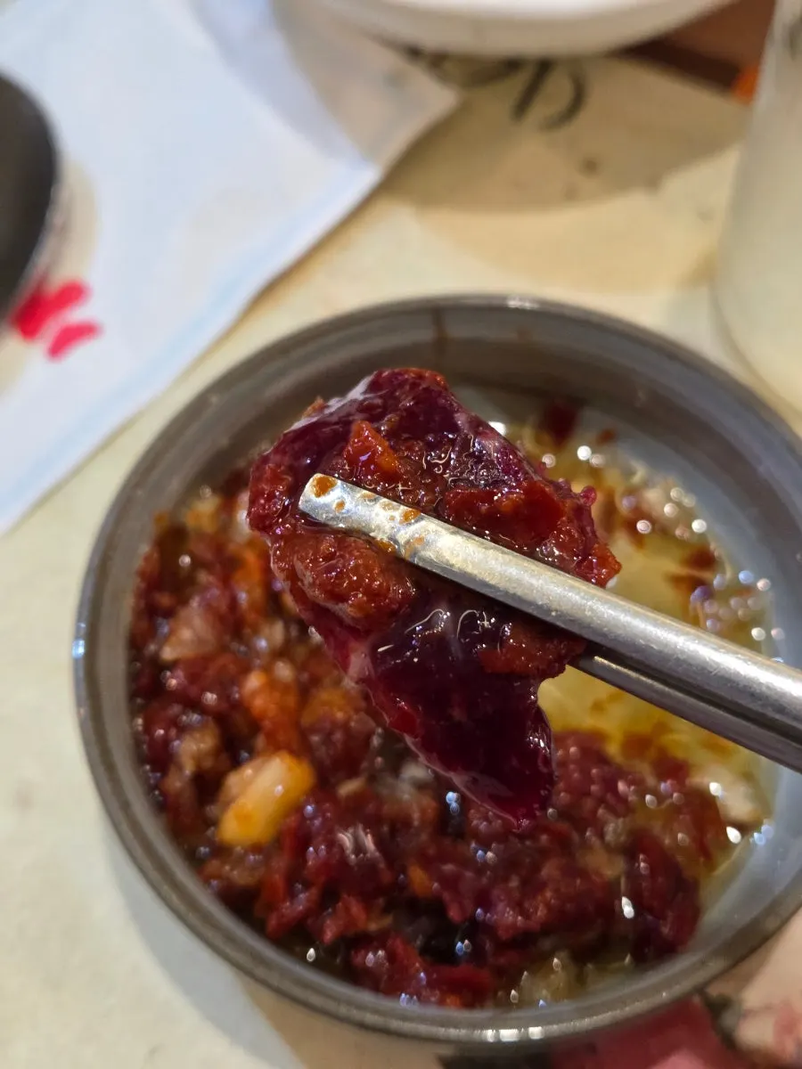 A piece of mungtigi dipped in makjang sauce