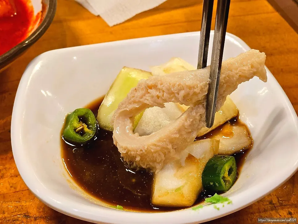 A piece of tripe dipped in sauce