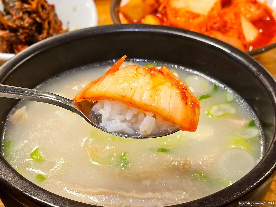 A spoonful of rice topped with kimchi and kkakdugi
