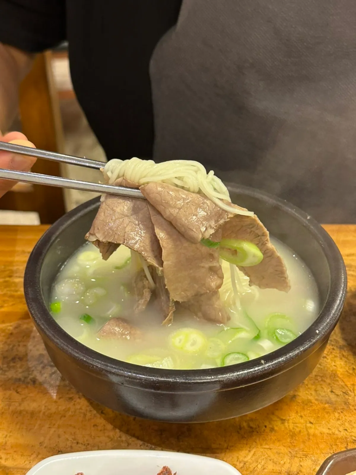 A bowl of Hanwoojang seolleongtang with milky broth