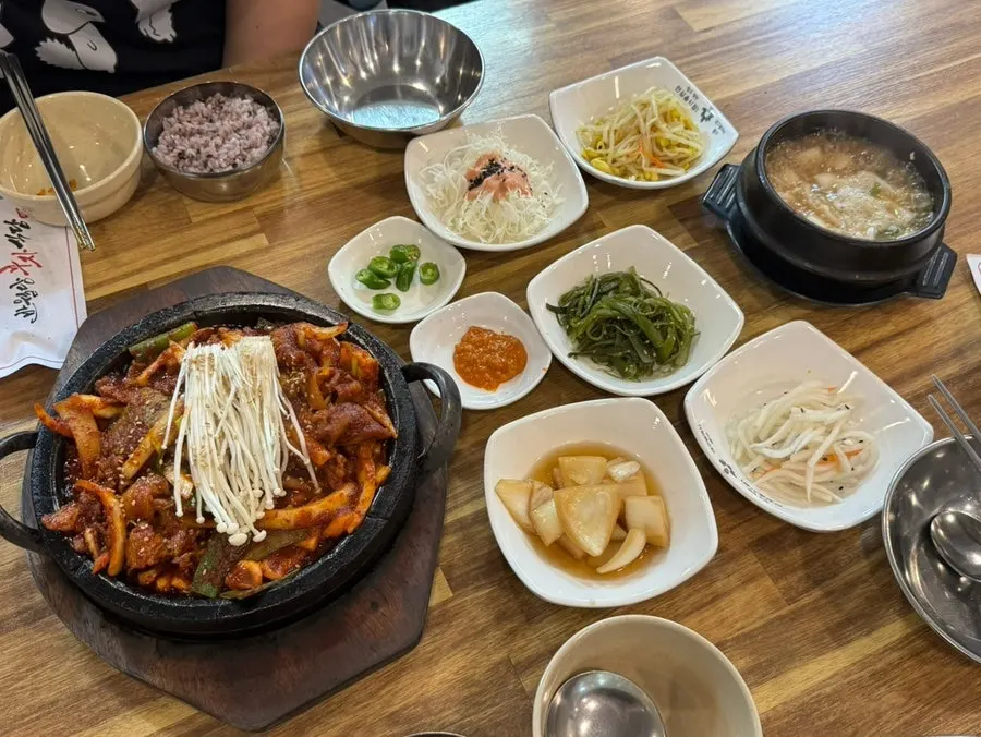 Sizzling squid and pork stir-fry cooking on a hot stone plate
