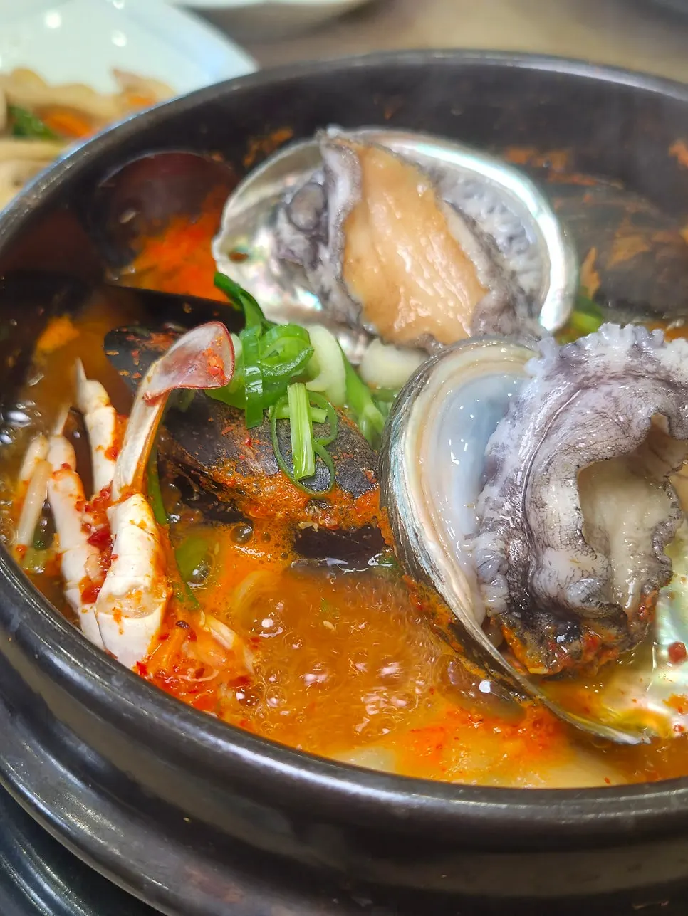 Representative photo of a seafood stew spread topped with live abalone
