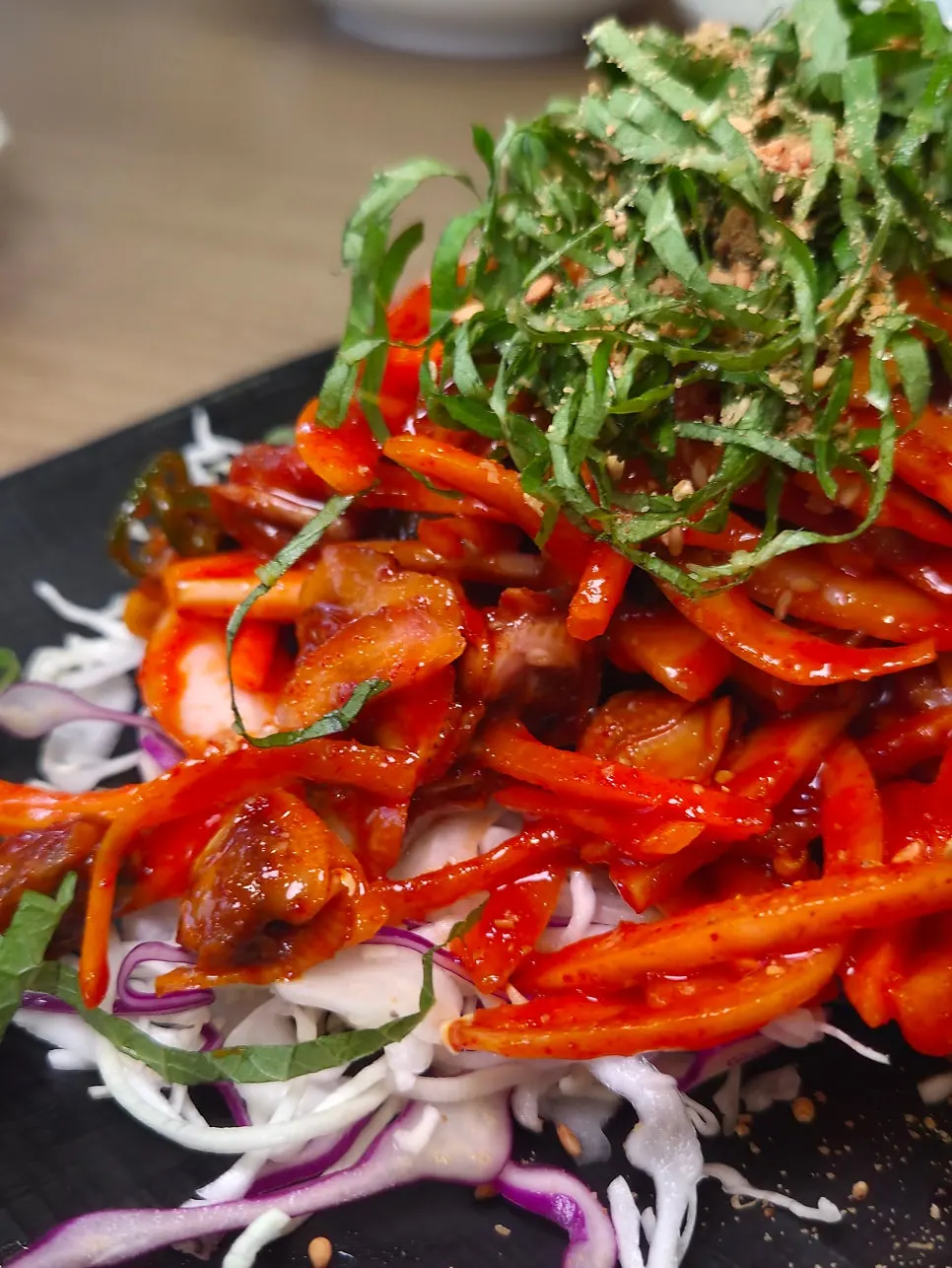 A chopstick's worth of cockle salad being lifted