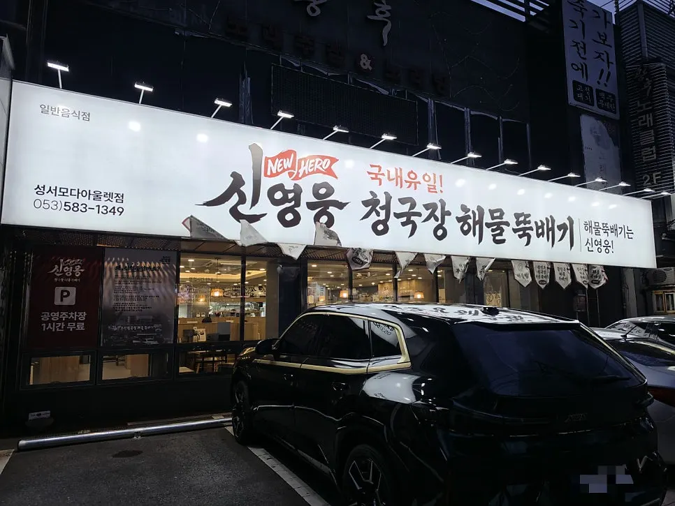 저녁에 밝게 켜진 흰색 간판의 식당 외관