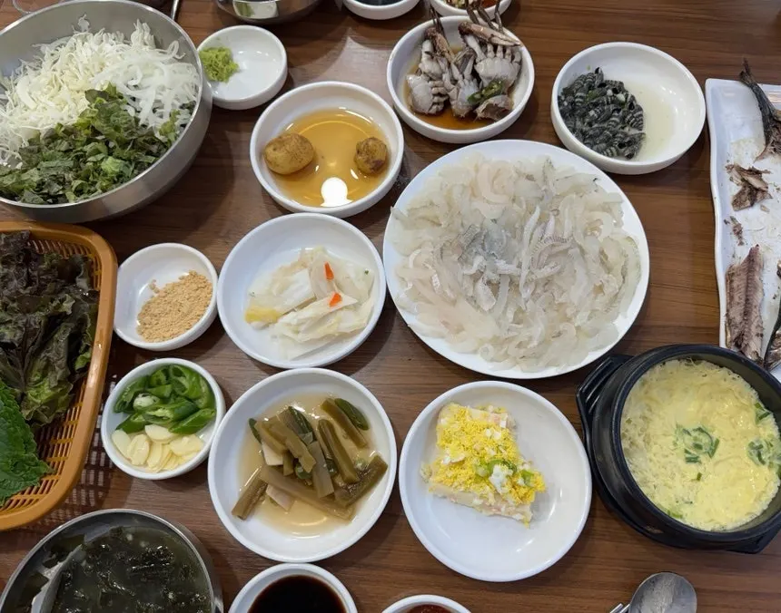 밑반찬과 노랑가자미회가 함께 놓인 상차림 전체샷