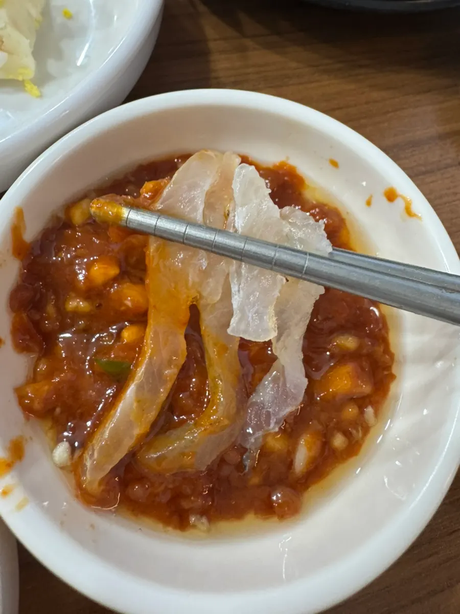 젓가락으로 집은 가자미회 한 점