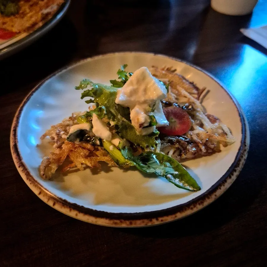 A piece of shredded potato pancake topped with burrata