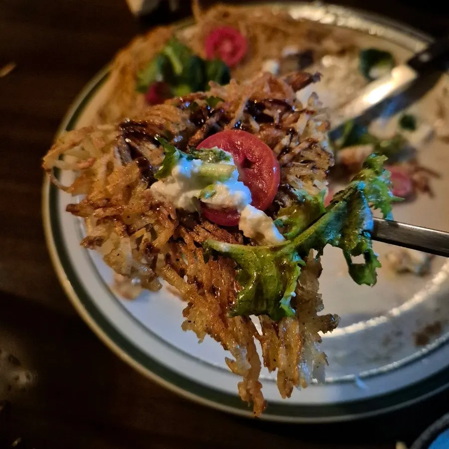Shredded potato pancake with cheese and salad