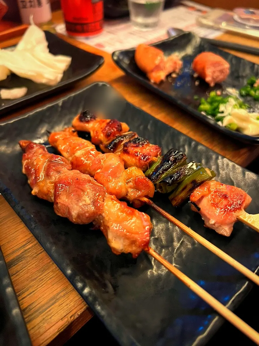 Tsukune being dipped into the egg yolk