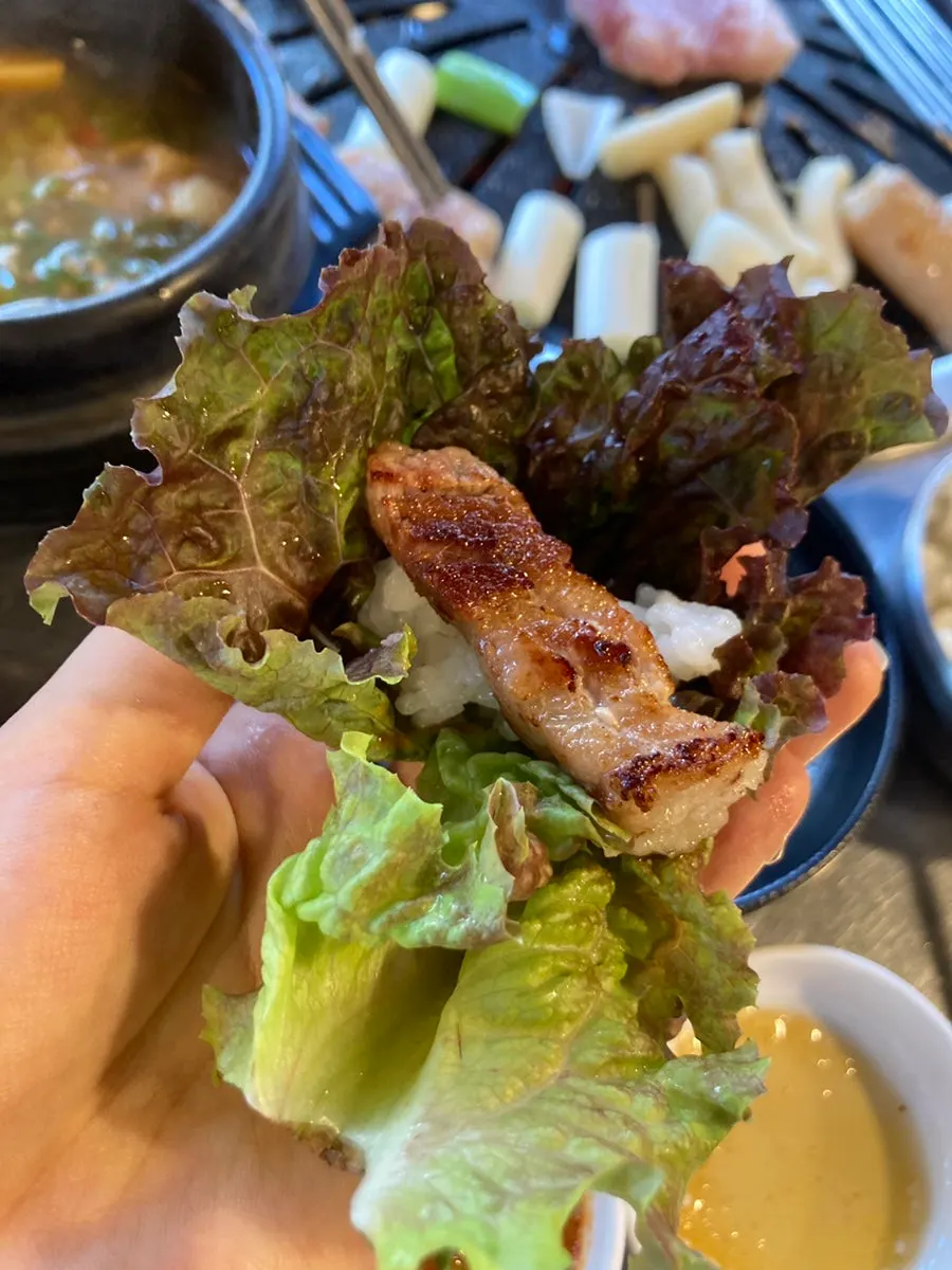 Flipping the pork belly and makchang with tongs