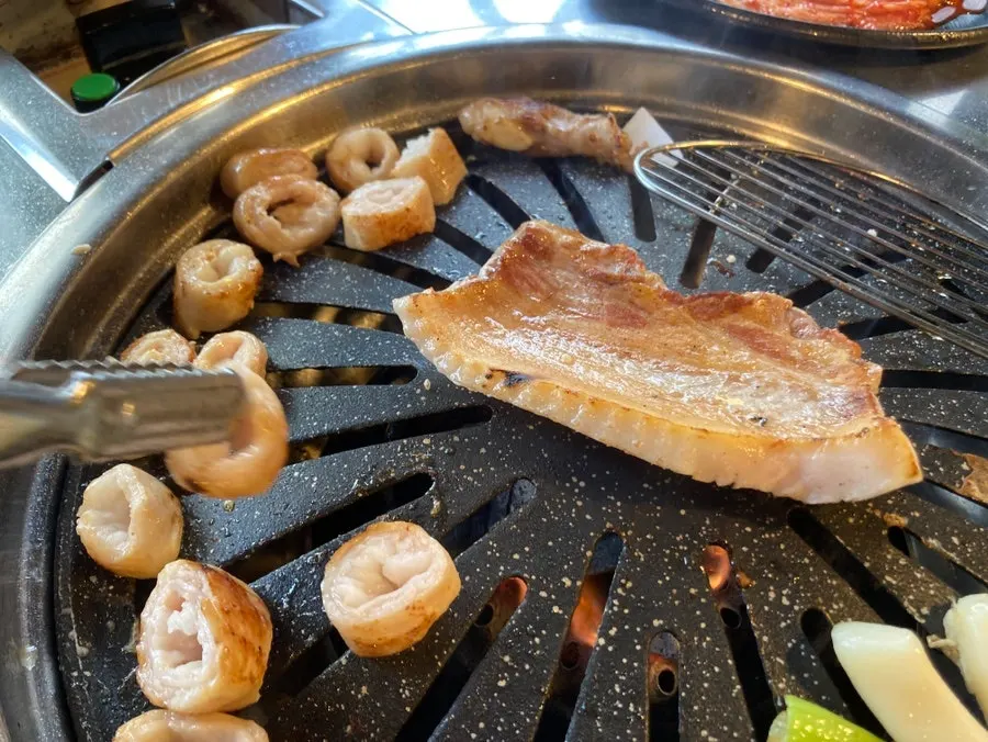 Meat cooking on the grill with wrap vegetables on a plate