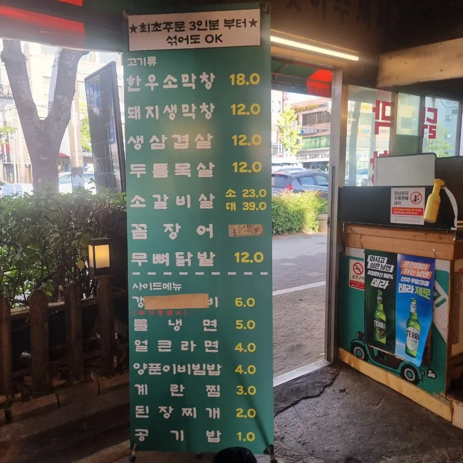 Menu board showing prices for raw pork makchang and raw pork belly
