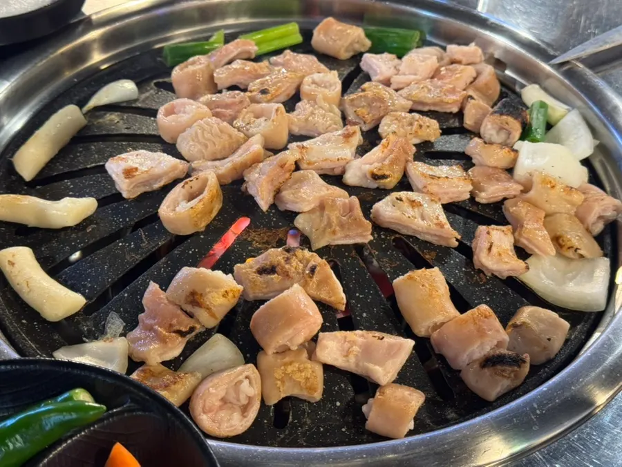 Raw makchang turning golden brown on the grill
