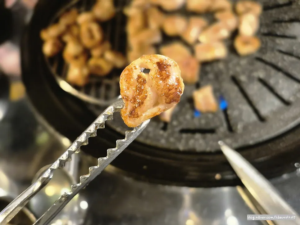 Raw pork makchang turning golden-brown on the grill