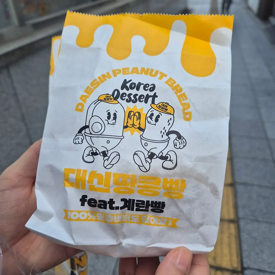 Yellow paper bag with a character design holding egg bread