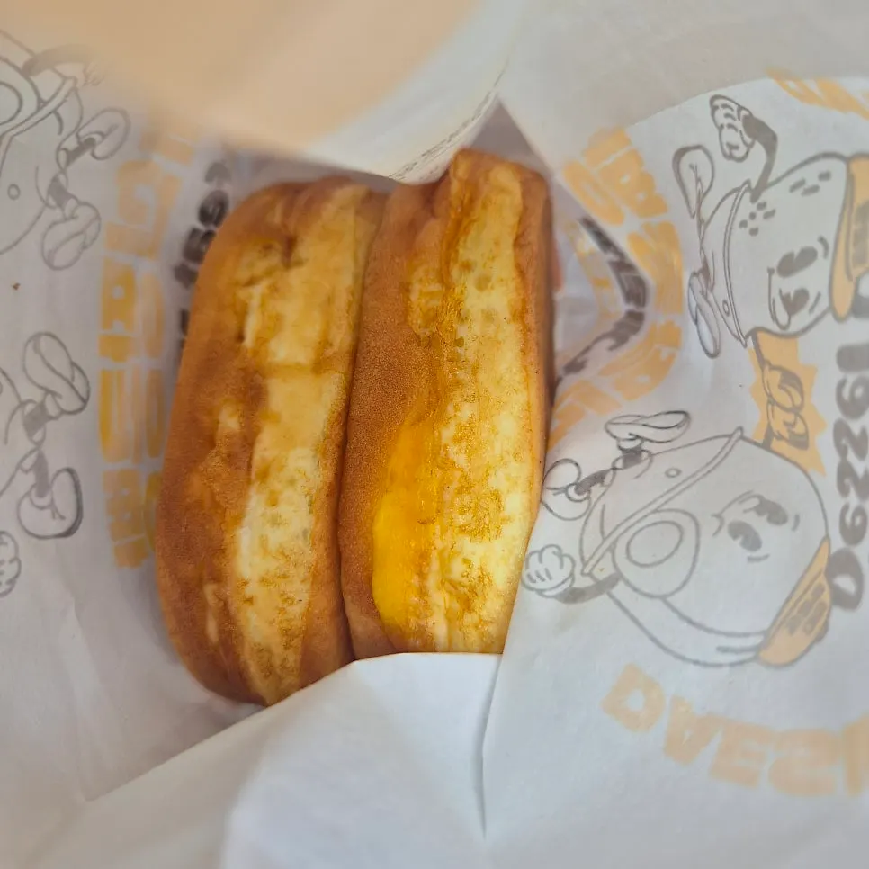 Two egg breads inside a paper bag