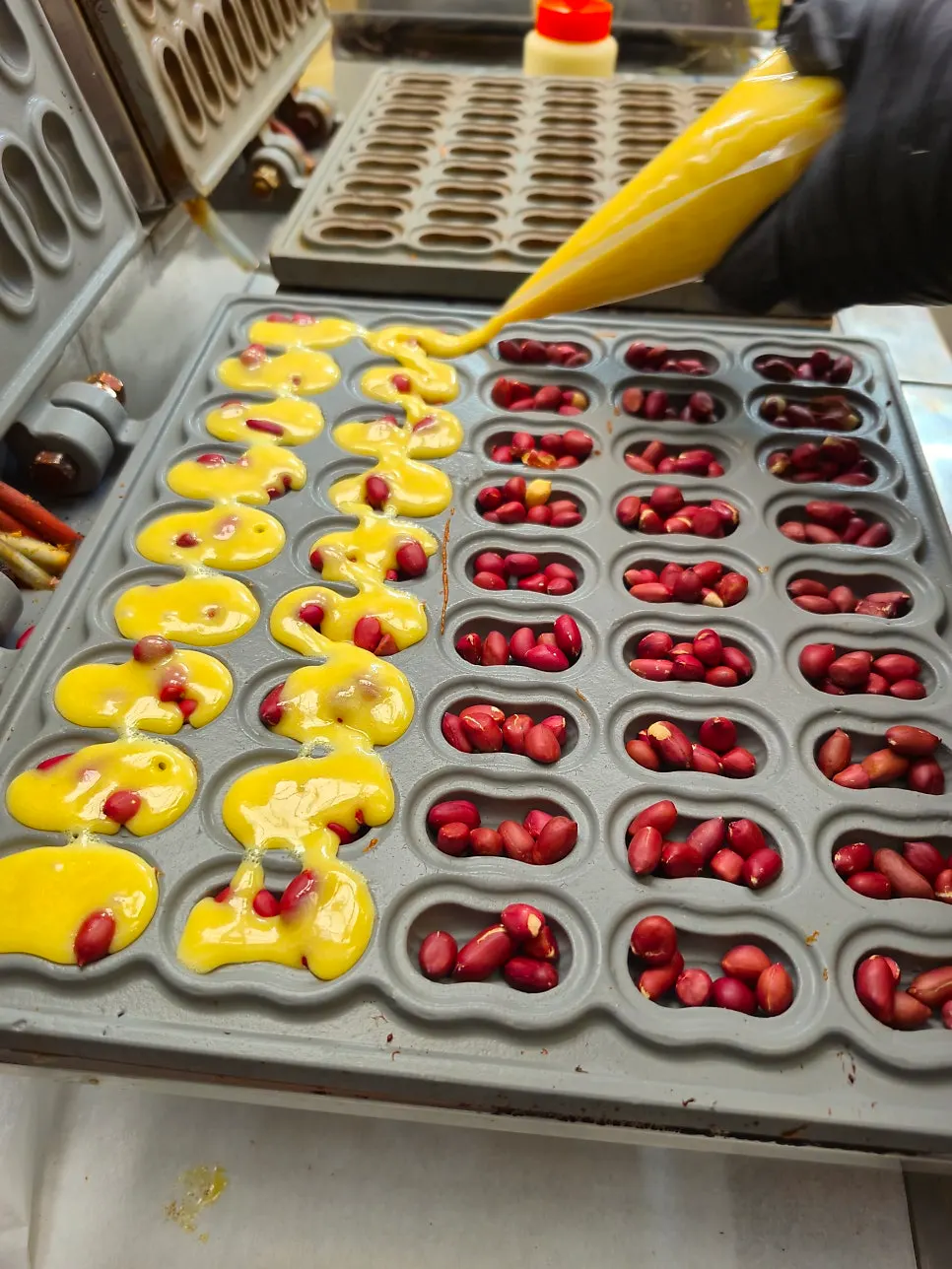 Peanuts being placed into peanut bread batter before baking