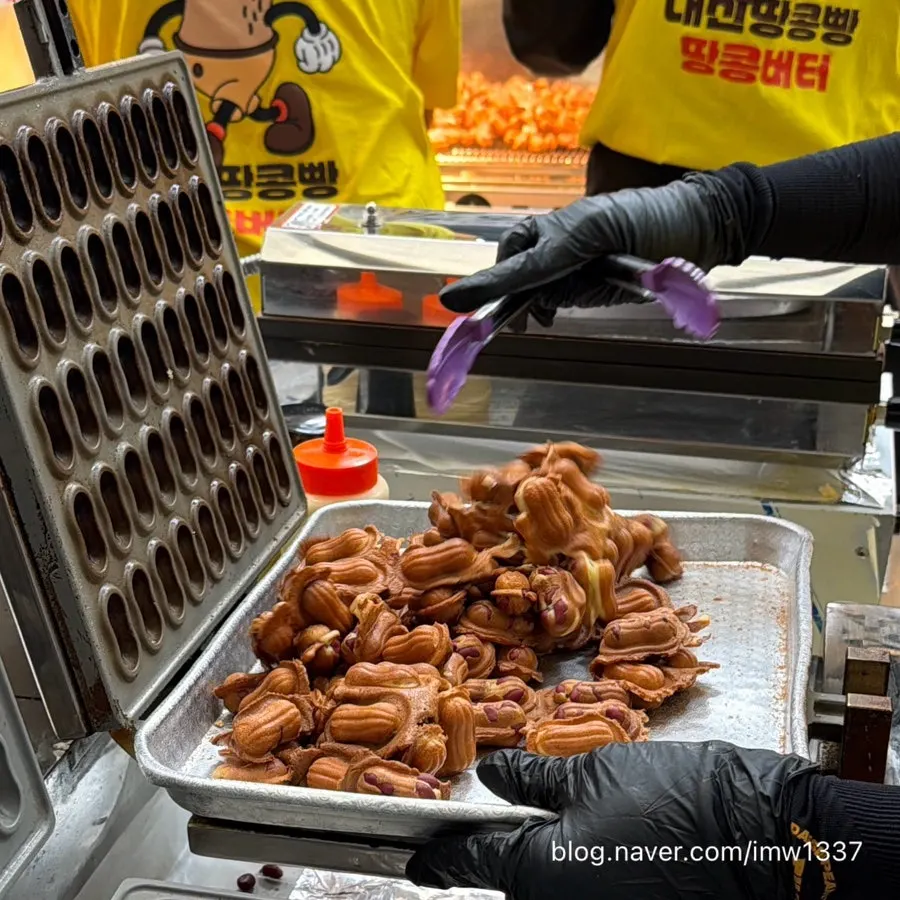 Freshly baked peanut bread pouring out of the machine