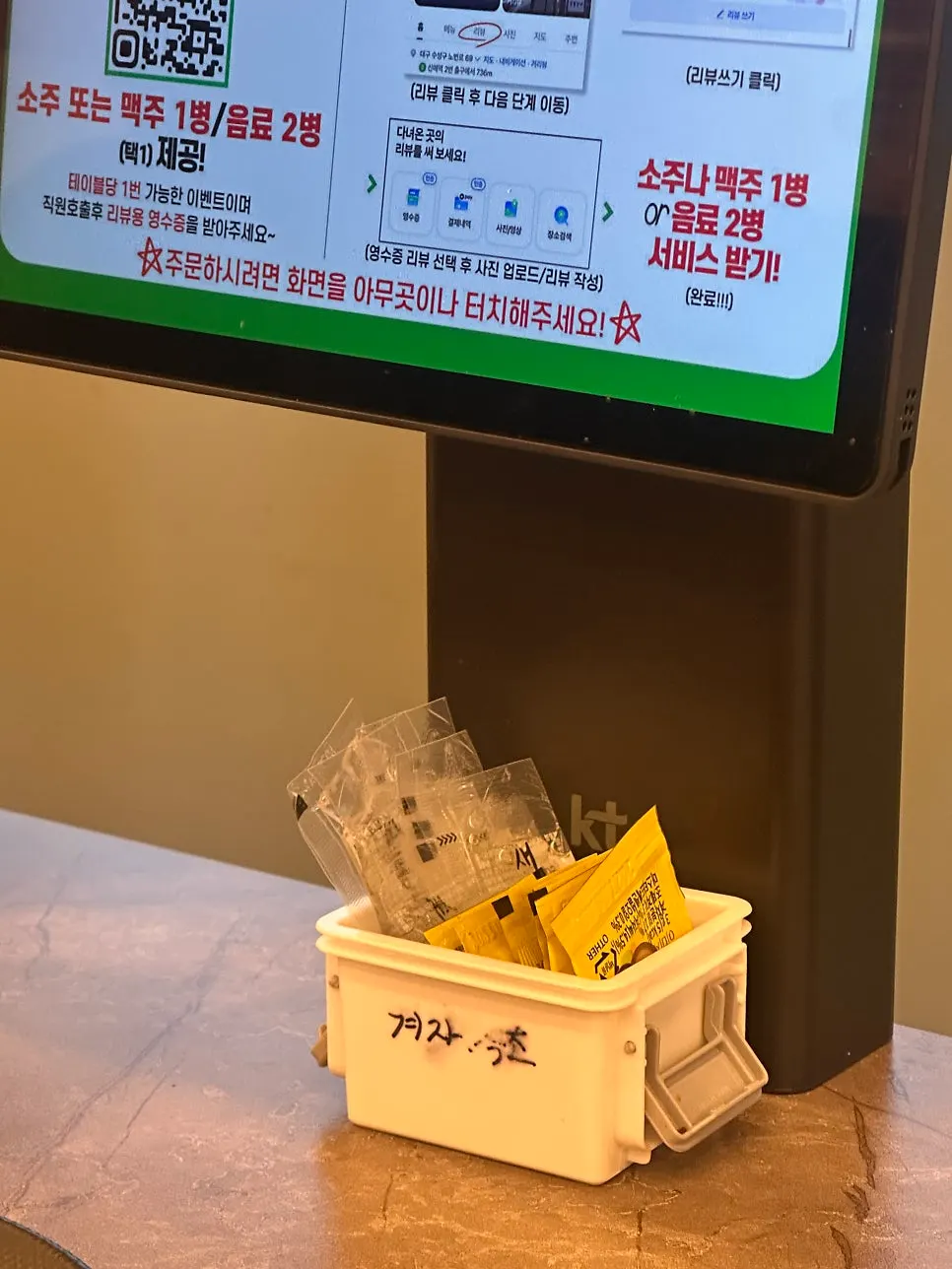 Disposable vinegar and mustard packets under the ordering tablet