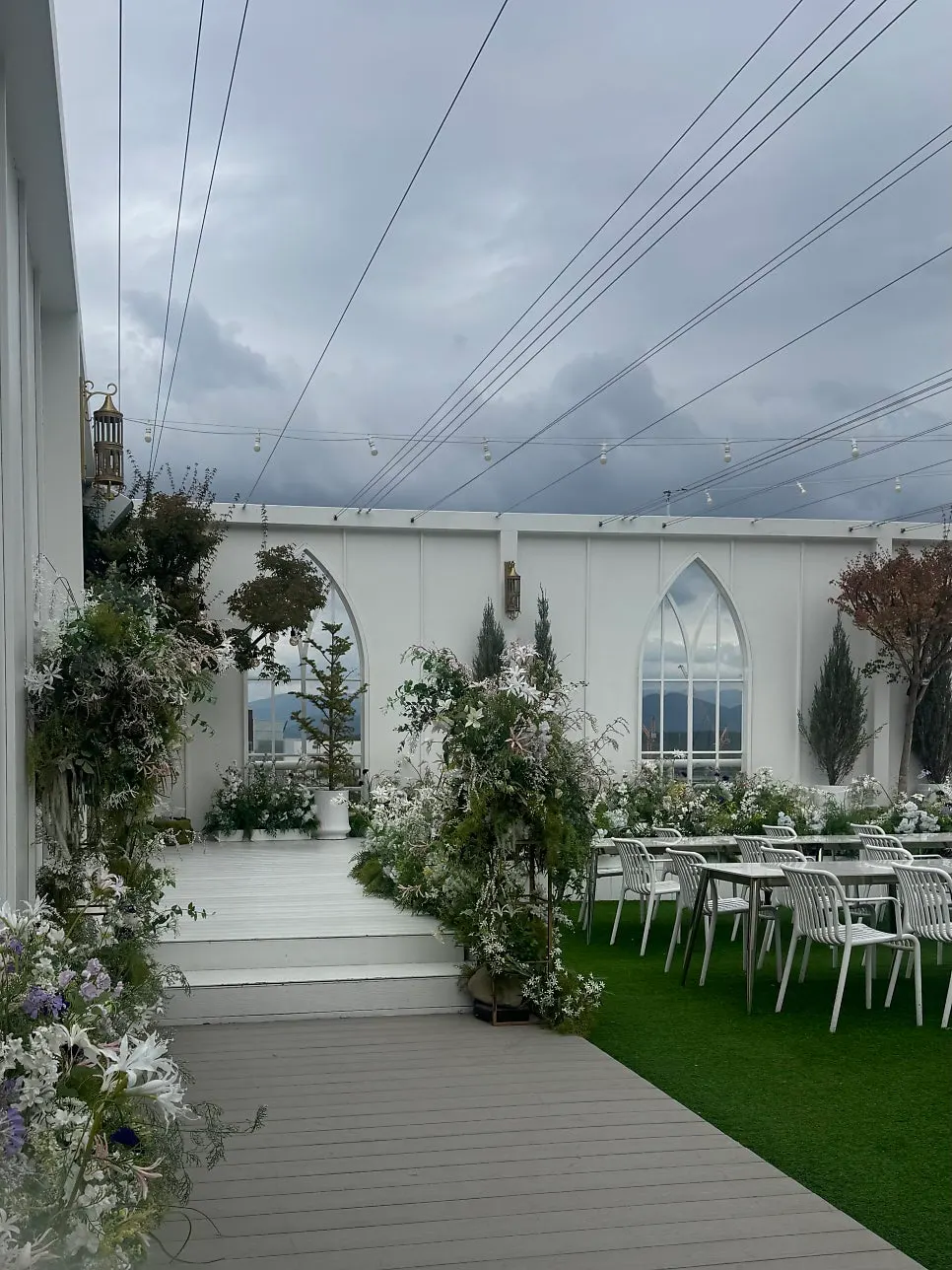 Outdoor ceremony space with green plants and floral decorations