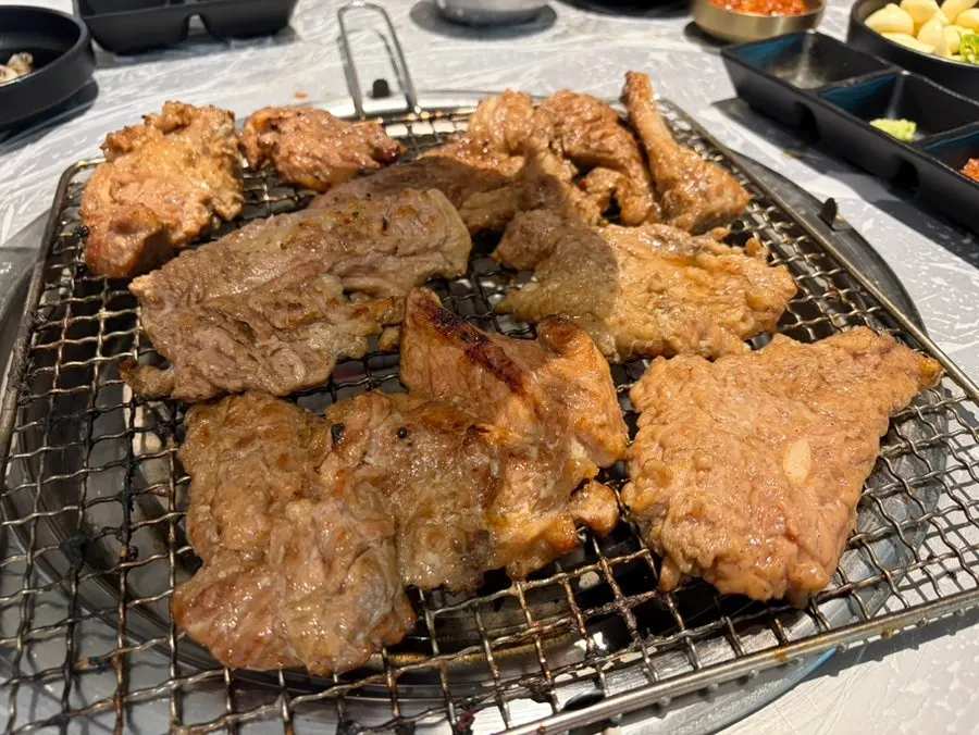 Pork galbi being pre-grilled over charcoal