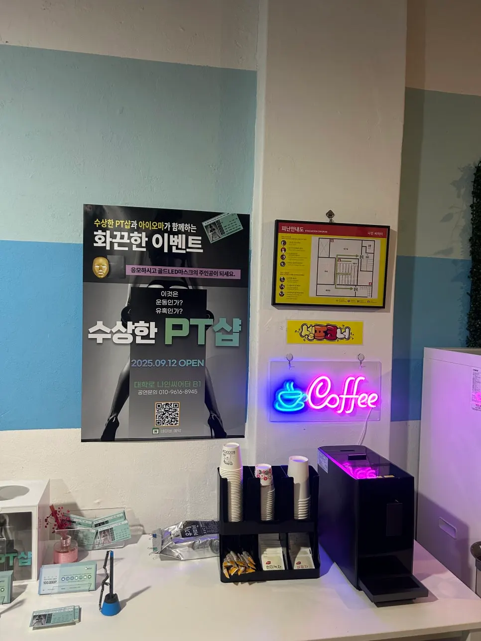 커피 네온사인이 걸린 대기 공간 셀프 음료 코너